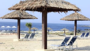 Am Strand, weißer Sandstrand, Liegestühle, Sonnenschirme