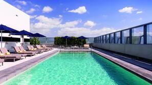 Una piscina al aire libre, sombrillas