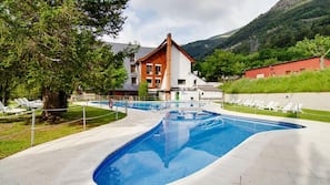 Una piscina al aire libre de temporada, tumbonas