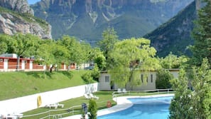 Una piscina al aire libre de temporada, tumbonas