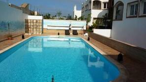 Piscine couverte, piscine extérieure, parasols de plage, chaises longues