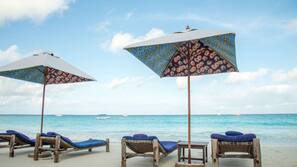 Plage, sable blanc, chaises longues, parasols