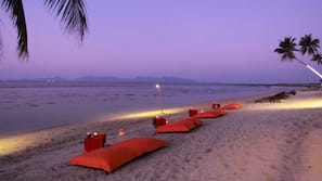Trên bãi biển, cát trắng, ghế dài tắm nắng, dù trên bãi biển