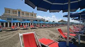 Sulla spiaggia, lettini da mare, ombrelloni