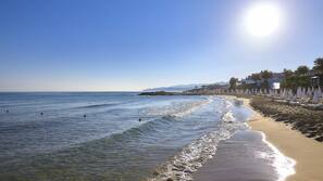 White sand, sun-loungers, beach umbrellas, beach towels