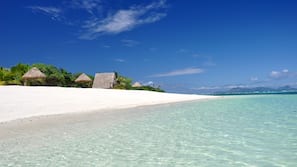 On the beach, white sand, sun-loungers, beach umbrellas