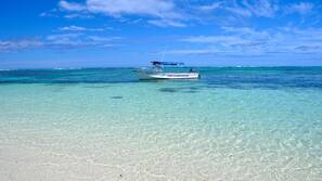 On the beach, white sand, sun-loungers, beach umbrellas
