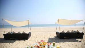 Pantai pribadi, pasir putih, kursi berjemur, dan payung pantai