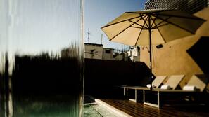 Una piscina al aire libre, sombrillas