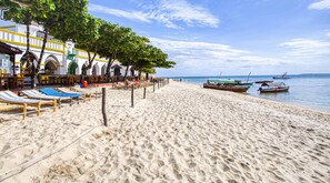 On the beach, white sand, sun loungers, beach towels