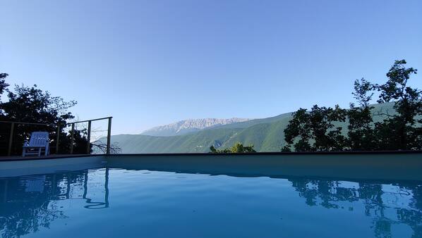Una piscina al aire libre de temporada, tumbonas