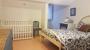 1 dormitorio, tabla de planchar con plancha, cunas o camas infantiles