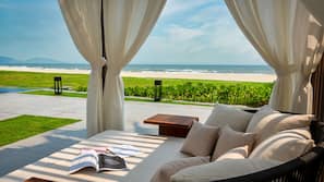 Pantai pribadi, pasir putih, kursi berjemur, dan payung pantai