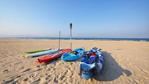Pantai pribadi, pasir putih, kursi berjemur, dan payung pantai