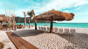 On the beach, white sand, beach umbrellas, beach towels