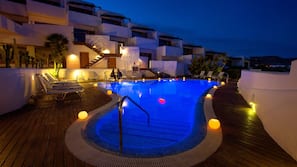 Una piscina al aire libre, tumbonas
