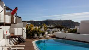 Una piscina al aire libre, tumbonas
