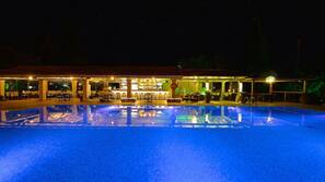 Una piscina al aire libre, sombrillas, tumbonas