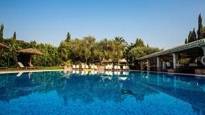Una piscina al aire libre, sombrillas, tumbonas