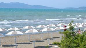 Una spiaggia nelle vicinanze, sabbia bianca, lettini da mare, ombrelloni