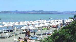 Una spiaggia nelle vicinanze, sabbia bianca, lettini da mare, ombrelloni