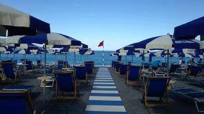 Sulla spiaggia, lettini da mare, ombrelloni, pallavolo