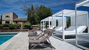 Una piscina al aire libre, tumbonas