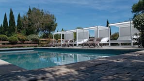 Una piscina al aire libre, tumbonas