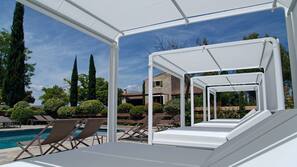 Una piscina al aire libre, tumbonas