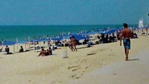 On the beach, white sand, beach umbrellas, beach towels