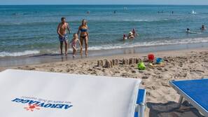 On the beach, sun loungers, beach umbrellas, windsurfing