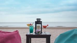 In Strandnähe, weißer Sandstrand, Sonnenschirme, Strandtücher