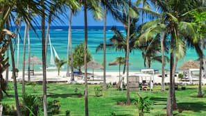 Plage, sable blanc, chaises longues, parasols