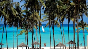 Plage, sable blanc, chaises longues, parasols