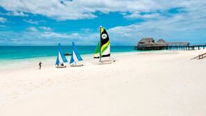 Plage, sable blanc, chaises longues, parasols