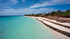 Plage, sable blanc, chaises longues, parasols