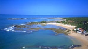 Na praia, espreguiçadeiras, toalhas de praia, massagens na praia