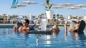 Una piscina al aire libre, sombrillas, tumbonas