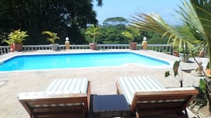 Una piscina al aire libre, tumbonas