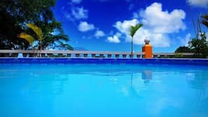 Una piscina al aire libre, tumbonas