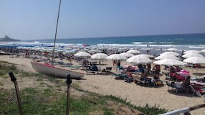 Una spiaggia nelle vicinanze, sabbia bianca, lettini da mare, ombrelloni