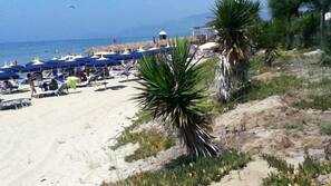 Una spiaggia nelle vicinanze, sabbia bianca, lettini da mare, ombrelloni