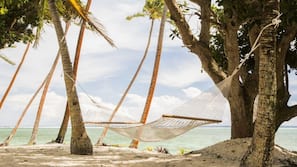 On the beach, white sand, sun loungers, beach towels