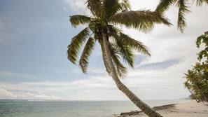 On the beach, white sand, sun loungers, beach towels