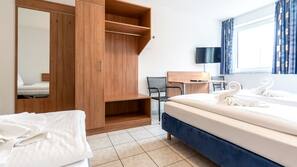 Biancheria da letto ipoallergenica, una scrivania, tende oscuranti