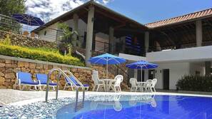Una piscina al aire libre, sombrillas