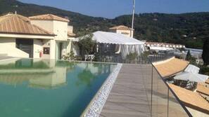 Piscine extérieure, parasols de plage, chaises longues