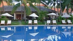 Una piscina al aire libre, sombrillas, tumbonas