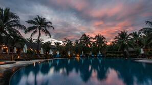 Una piscina al aire libre, sombrillas, tumbonas