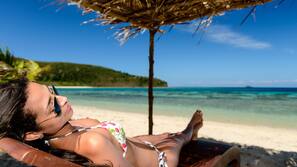 On the beach, white sand, sun-loungers, beach towels